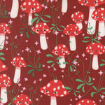 Pattern of red and white mushrooms with green leaves on a red background
