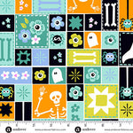 Halloween-themed fabric pattern with squares featuring ghosts, bones, and flowers, measured by a ruler.