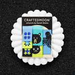 Product packaging with 'Crafted Moon' branding and artwork by Sarah Watts on a black background.