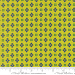 Fabric with blue and green geometric pattern on a yellow background, featuring a ruler at the bottom.