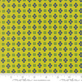 Fabric with blue and green geometric pattern on a yellow background, featuring a ruler at the bottom.