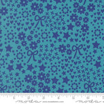 Blue fabric pattern with stars, flowers, and bows on a blue background, featuring Moda label.