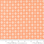 Patterned fabric with white geometric design on a peach background, featuring Moda label.