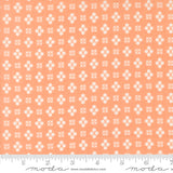 Patterned fabric with white geometric design on a peach background, featuring Moda label.