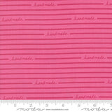 Pink fabric with 'handmade' text and Moda label, featuring a ruler for scale.