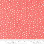 Coral fabric with white polka dots and a ruler at the bottom