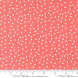 Coral fabric with white polka dots and a ruler at the bottom