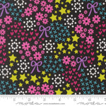 Colorful fabric pattern with stars, flowers, and bows on a black background, featuring Moda label.