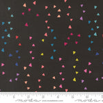 Colorful triangle pattern on black fabric with Moda label and ruler at the bottom.