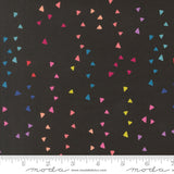 Colorful triangle pattern on black fabric with Moda label and ruler at the bottom.
