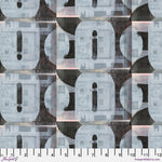 Patterned fabric with geometric shapes and a ruler at the bottom for scale.