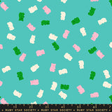 Pattern of colorful gummy bears on a teal background with a ruler at the bottom.