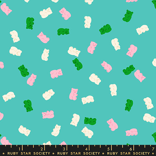 Pattern of colorful gummy bears on a teal background with a ruler at the bottom.