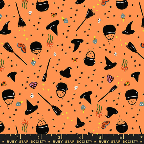 Halloween-themed fabric pattern with witch hats, brooms, and candy on an orange background.
