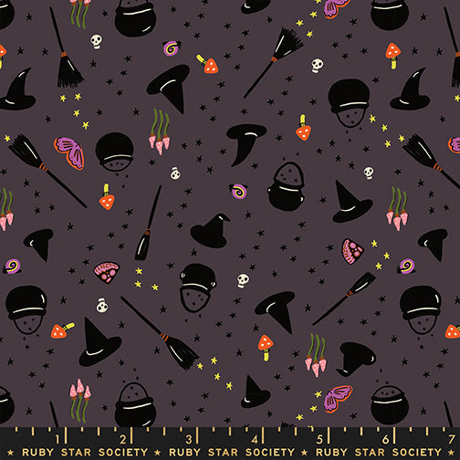 Halloween-themed fabric pattern with witch hats, brooms, and cauldrons on a dark background.