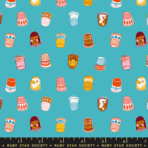 Pattern of colorful thimbles and sewing-related items on a blue background with Ruby Star Society label.