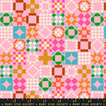Colorful geometric pattern fabric with a ruler at the bottom on a pink background