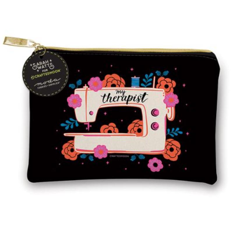 A black zippered pouch featuring a retro-style illustration of a cream sewing machine surrounded by pink and orange flowers, with the text 'my therapist' and a hanging circular tag reading 'Sarah + WIP x CRAFTEDMOON'.